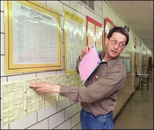Dennis Lynn points out his popular assignments-on-the-wall practice. The hallway walls at Newton D. Baker Elementary School are like his canvas for learning materials. Mr. Lynn, a Title 1 teacher at the school, is called 'the best math teacher in the whole state of Ohio' by his former principal. 