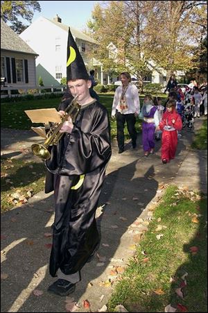 Trumpet-playing wizard Ryan Haack leads his costumed schoolmates through the Beverly Elementary nighborhood in South Toledo. Pupils kick off Halloween by taking part in the school's annual costume parade.