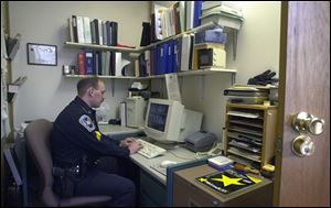 Sgt. Tim Livengood works at his computer terminal in the tiny office he shares with Sgt. Jim Brace at Montpelier police headquarters. The office is too cramped for the two sergeants to be working during the same shift.