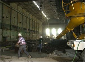 Workers smooth out the concrete they have poured inside the former Toledo Edison steam plant.