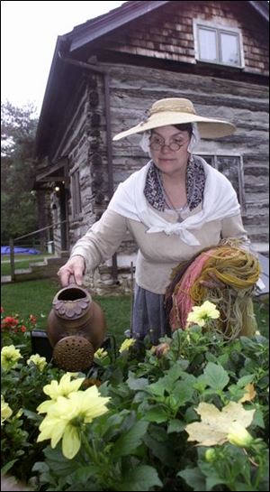 Susan Cayton, in pioneer-style attire she has created using old-fashioned methods, tends her Dyer's Garden.
