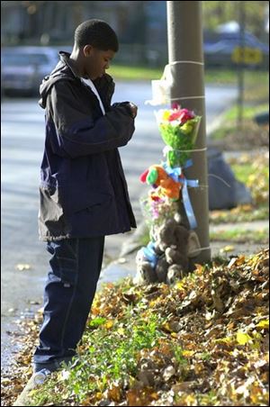 Tim Carter pauses in front of a homemade memorial to his 3-year-old neighbor, Malek White, on West Delaware Avenue near Trenton Avenue.