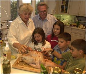 Richard and Marion Gross prepare a turkey for roasting in their kitchen with the assistance of 4 of their 11 grandchildren. The helpers are, from left, Samantha Collins, 10; Ali Collins, 12; and 9-year-old twins Sam and Alex Gross.