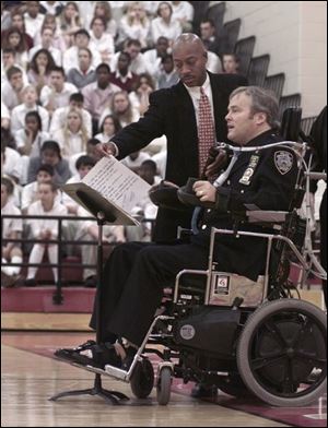Jon Williams, left, a New York City police officer, assists Steven McDonald during a presentation at Central Catholic High School.