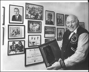 Bob Snyder displays some mementos of a lifetime in a 1986 photo. He played at Libbey High and Ohio U, then in the NFL (Cleveland, Chicago), and coached both college and NFL teams.