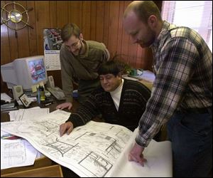 Jones & Henry workers, from left, Peter Latta, Al Zamora, and Brad Lowery look over plans.
