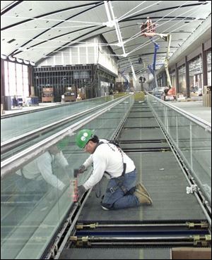 Dan Misuraca of Otis Elevator works on a moving walkway in the midfield terminal at Detroit Metropolitan-Wayne County Airport.