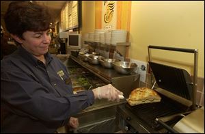 Susan Taylor of Panera Bread takes a panini from the press.