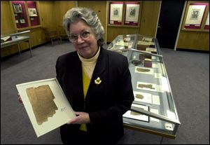 Librarian Kathryn Beam holds a papyrus codex of the Letters of St. Paul in Greek.