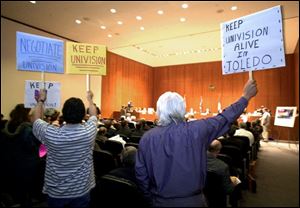 Daniel Juarez, left, and George Villarreal make their opinions on Univision known during the city council meeting.