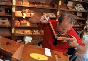 SEC receivers catalog the cigars from Mr. Mobley's cigar bar. Some 85-year-old cigars once sold for $3,000 apiece, but the entire 5,000 inventory was sold for $7,000.