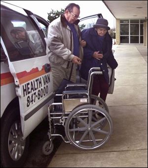 Health van driver John Giampino helps Juanita Tennyson of Dundee into a wheelchair as part of the service to the Great Lakes Dialysis Center in Monroe.