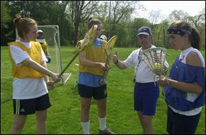 The topic is defense as lacrosse coach Paul Sieben works with, from left, Ann Stewart, Amanda Kruse and Sarah Wilcox.