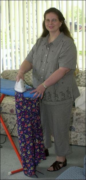 Ann Szilagye irons a dress for one of her daughters in her Point Place home.