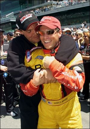 Scott Sharp gets a hug from a crew member after averaging 226.037 mph to lead yesterday's qualifying in Indianapolis.