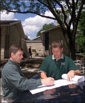 Landscape designers Doug Bettinger, left, and Matt Kowalski of FloraLandscape look over plans for a project at Epworth United Methodist Church. 