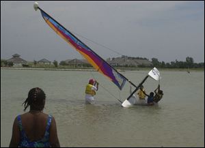 Art Stevens (on left holding the cable on the boat) of U.S. Sailing teaches water and sailing safety to members of the Maumee Vally Girl Scouts during the SAFE KIDS coalition of Toledo held at the Maumee Bay State Park. dutton CTY safe19p 2 JUNE 19 2001