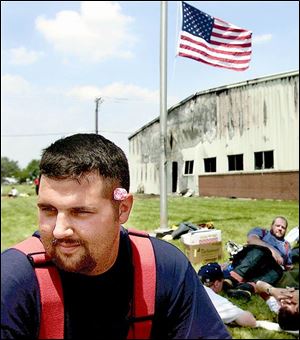Archbold firefighter Matt Welch, with a Dum Dums sucker tucked behind his ear, takes a break from fighting the Spangler Candy Co. warehouse fire.
