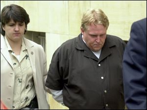 CTY August 2, 2001  Jimmie Woodland, of Fostoria,  leaves the Federal Courthouse in Toledo, Ohio under guard following his arraignment for the theft and interstate transport of the vehicle of Fred Smith of the Dayton area. Smith had been murdered previous to the theft.  [Person on left is unidentified. ] Jetta Fraser/Blade