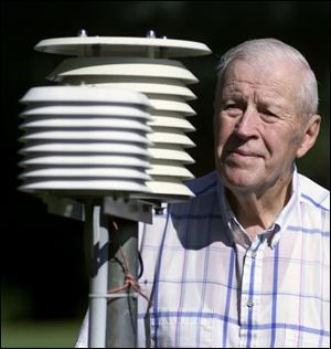 `I sleep a lot in the daytime,' says weather observer Ray Burkholder, checking his electronic temperature system.