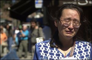 Wen Shi breaks into tears as she tries to find her husband, who worked at the World Trade Center. She was at the New York Armory, where police are establishing files on the missing.