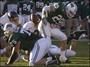Ohio's Ray Huston has the ball knocked loose by Tom Ward, center. Ohio, which was leading the nation in rushing with 282.3 yards per game, ran for 194 yards last night.