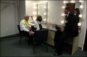 Lucas County treasurer Ray Kest is made up by Theresa Pollick of Maumee before the televised debate as Dave Huey of Sylvania reviews the mayoral candidate's opening statement.