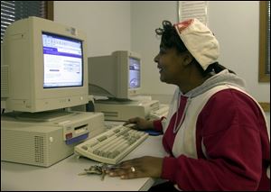 Tamara Samples does some job hunting on the computer at the Ohio Job and Family Services office on Airport Highway.