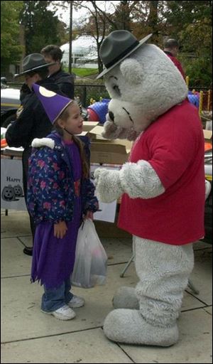 cty photo by don simmons oct 27, 2001 kayleigh tomanski age 7 talks wwith teddy trooper at the toledo zoo's 17th annual pumpkin path .  this was the ohio highway patrol station at the zoo