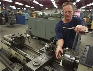 Larry Henry works on a lathe at Hause, which began in 1933 by making underground oil well equipment.