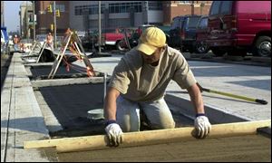 cty photo by don simmons nov 15, 2001 mitch cousino  works on leveling sand before the placement of bricks in the new sidewalks under construction  along huron st near the new mud hens stadium