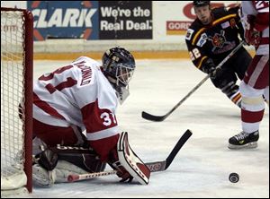 Toledo goaltender Joey MacDonald stops a first-period shot as Wheeling's Jeremy Brown (22) moves in for a rebound last night at the Sports Arena. MacDonald made 33 saves against the Nailers.