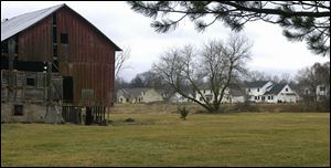 A barn at Dean and Douglas roads in Bedford Township, Michigan, contrasts with new housing developments nearby.
