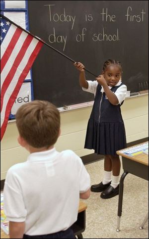 First grader Ja Shayla Motley does her part during the pledge of allegiance at Toledo's Old West End Academy.