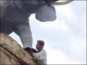 Tom Koleszar, builder and contractor for the Putt-Putt golf course on Heatherdowns Blvd. checks the braces for the elephant on top of one of the hills at the course. If the weather allows, they are hoping to be open for the 'golfing season' this week-end. lisa dutton ROV putt-putt MAR 12 2002