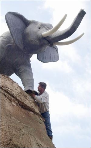 Tom Koleszar, builder and contractor for the Putt-Putt golf course on Heatherdowns Blvd. checks the braces for the elephant on top of one of the hills at the course. If the weather allows, they are hoping to be open for the 'golfing season' this week-end. lisa dutton ROV putt-putt MAR 12 2002
