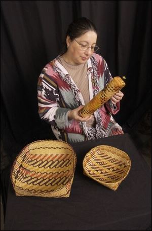 Rhonda Remedies Gauthier of the Choctaw-Apache tribal community from Ebarb, La., examines the baskets from the Malmberg collection on display at the Williamson Museum.