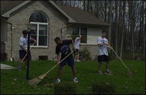 L.J. Helton, in the foreground, and Eric Sierra, Nick Engel, and Matt Knipp, from left behind him, do yard work at a home in Defiance. Nearly 150 students have been volunteering their time after school to do odd jobs for residents.