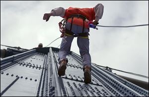 Brett Morris of Toledo rappels down the Anthony Wayne Bridge as part of his training.