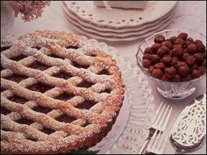 Blackberry Raspberry Linzertorte features a sugar-dusted lattice top over a sweet filling.