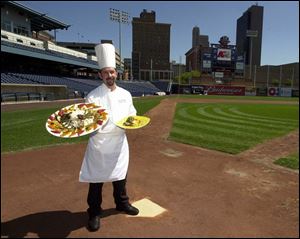 Scott Fuernstein, executive chef for Fifth Third Field, prepares everything from custom catering menus to premium ballpark food for the suites and special parties. Here he holds a feast of Grilled Chicken with Netto Pasta and Roasted Vegetables, left, and an individually plated grilled fillet entree.