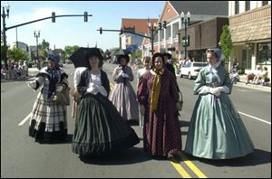 Violet Kyryluk, Sally Mialon, Larisa Flushman, and Ashley Wilhelm, from left, representing the 14th Ohio Volunteer Infantry, march down Main Street in Civil War-era attire during the Memorial Day parade held in Bowling Green.