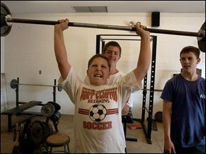 reg rover11p A June, 11, 2002. B.J. Johnson, 13, lifts weights for the upcoming football season as his friends Carey Clum, 13, and junior Adam Urban spot Tuesday at True Lay Stadium in Port Clinton, O. Johnson will play eighth grade football in the fall. Blade photo by Jeremy Wadsworth