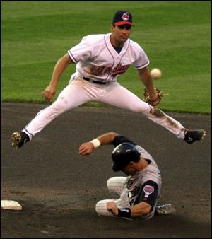 Tribe shortstop Omar Vizquel goes up and over Arizona runner Luis Gonzalez for a double play.