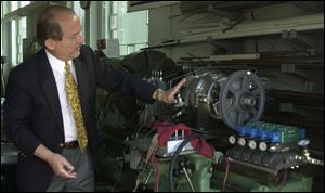 Ronald McMaster shows a McMaster rotary engine being tested at the University of Toledo.