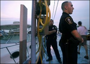 On the dock, police officers Jamison Rose, foreground, and Phil Howell help to make sure the law and fun don't clash.