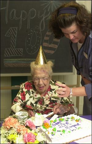 Margaret O'Hearn turned 100 years old on July 3. Julie Dangelo gives her a little help with her cake.