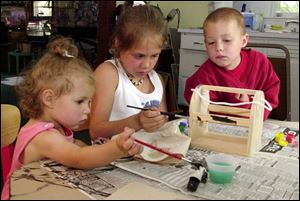 From left, Krinn Keller, 1, Kayla Keller, 8, and Kamren Keller, 3, work on a bug house during `A Bug's Life' summer camp at Toledo Botanical Garden.