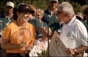 Rachel Teske holds the trophy as she accepts a big check - for $150,000 - from Jamie Farr. Part of her earnings will go toward the extra plane fare she incurred because of a travel snafu.