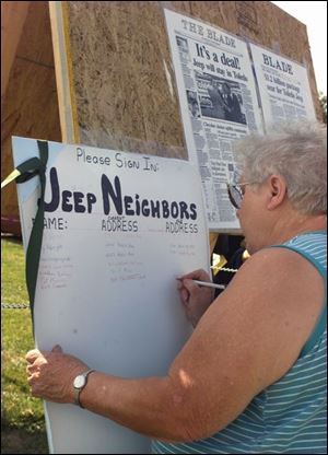 Displaced neighbor Pat Bensen signs in at the outset of the reunion held near the plant.